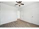 Bedroom with wood-look floors, ceiling fan, and interior door at 2748 Garden Plum Pl, Odessa, FL 33556