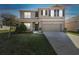 Two-story home at dusk featuring a two car garage, neutral color palette, a well-maintained lawn and mature landscaping at 2748 Garden Plum Pl, Odessa, FL 33556