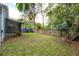 Backyard features a fenced perimeter, a lawn with fallen leaves, and exterior storage at 311 W Chelsea St, Tampa, FL 33603