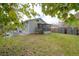 Wide backyard view featuring a patio seating area, gray storage sheds, and partial tree coverage at 311 W Chelsea St, Tampa, FL 33603