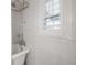 Close up of a claw foot bathtub with white subway tile and a white shuttered window at 311 W Chelsea St, Tampa, FL 33603