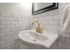 This is a close-up of a white sink with gold fixtures and white subway tile at 311 W Chelsea St, Tampa, FL 33603