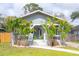 Charming home featuring mature palms, a gray exterior, a welcoming front porch, and a well-manicured lawn at 311 W Chelsea St, Tampa, FL 33603