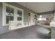 Comfortable front porch with a white swing and chair, complemented by the home's gray exterior and white trim at 311 W Chelsea St, Tampa, FL 33603