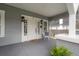 Inviting front porch with decorative white chair, complemented by the home's gray exterior and white trim at 311 W Chelsea St, Tampa, FL 33603
