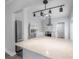 Bright white kitchen features stainless appliances, apron front sink, black hexagon tile, and marble countertops at 311 W Chelsea St, Tampa, FL 33603