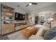 Bright living room with built-in shelving, TV, and comfortable sectional sofa and ottoman at 311 W Chelsea St, Tampa, FL 33603