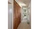 Hallway with wood closet doors leading to a cozy bedroom with comfortable furniture at 312 S Port Royal Ln, Apollo Beach, FL 33572