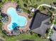 Overhead view of community pool with chairs, patio and walkway surrounded by green space at 35661 Jenny Lynne Cir, Zephyrhills, FL 33541