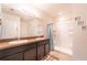 Bright bathroom with a double vanity, framed mirror, and a walk-in shower with tiled walls at 35661 Jenny Lynne Cir, Zephyrhills, FL 33541