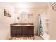 Bathroom with a double vanity, framed mirror, and a walk-in shower with tiled walls at 35661 Jenny Lynne Cir, Zephyrhills, FL 33541
