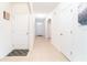 Bright hallway with neutral tile flooring, white walls, and multiple doors, creating an inviting entrance at 35661 Jenny Lynne Cir, Zephyrhills, FL 33541