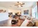 Living room with hardwood floors, neutral sofas, and a view into the kitchen and dining area for open-concept living at 35661 Jenny Lynne Cir, Zephyrhills, FL 33541