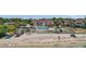 Community aerial view of a pool, beach, kayaks, and well-maintained buildings with palm trees and mature foliage at 3710 41St S Way # D, St Petersburg, FL 33711