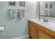 Light blue bathroom with single sink vanity and decorative wall hangings at 3710 41St S Way # D, St Petersburg, FL 33711