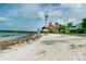 Beautiful beach view of waterfront homes with palm trees under a partly cloudy, blue sky at 3710 41St S Way # D, St Petersburg, FL 33711