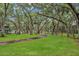Lush greenspace with mature trees and a walking path leading to community amenities at 3710 41St S Way # D, St Petersburg, FL 33711