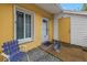 Inviting yellow home with a white trimmed window and an open door that is number 67D with a blue chair at 3710 41St S Way # D, St Petersburg, FL 33711
