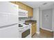 Traditional kitchen with wood cabinets, granite countertops, and white appliances at 3710 41St S Way # D, St Petersburg, FL 33711