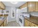 Bright kitchen with white appliances, granite countertops, and ample cabinet space at 3710 41St S Way # D, St Petersburg, FL 33711