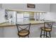 Charming kitchen bar with seating and a view into the kitchen, white appliances, and a paradise sign at 3710 41St S Way # D, St Petersburg, FL 33711