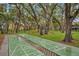 Community shuffleboard court nestled amongst mature trees, with a playground and seating nearby at 3710 41St S Way # D, St Petersburg, FL 33711