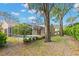 Landscaped backyard featuring a screened-in pool area and a well-maintained lawn at 4243 Tremblay Way, Palm Harbor, FL 34685