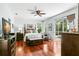 Spacious main bedroom featuring hardwood floors, a ceiling fan, and a sliding glass door to the pool area at 4243 Tremblay Way, Palm Harbor, FL 34685