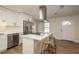 Kitchen view with white cabinets, an island with bar stools, and stainless-steel appliances at 4408 W Varn Ave, Tampa, FL 33616