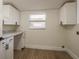 Bright laundry room featuring white cabinets, a countertop, and a window at 4408 W Varn Ave, Tampa, FL 33616