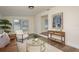 Bright living room featuring a brown couch, white chair, and a glass coffee table on top of a cream rug at 4408 W Varn Ave, Tampa, FL 33616