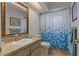 Bright bathroom featuring marble countertops, a gold framed mirror, and a shower with curtain at 4450 Dior Rd, Spring Hill, FL 34609