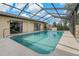 Large in-ground pool featuring an enclosed screen and open pool deck with seating at 4450 Dior Rd, Spring Hill, FL 34609