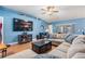 Comfortable living room featuring a large-screen TV, a plush sectional sofa, and wood-look laminate flooring at 4613 Portobello Cir, Valrico, FL 33596