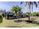 Landscaped backyard showcasing the screened pool, covered patio, and palm trees at 4617 Cloverlawn Dr, Tampa, FL 33624