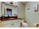 Well-lit bathroom featuring a vanity with a decorative mirror, white cabinets, and dark countertops at 4617 Cloverlawn Dr, Tampa, FL 33624
