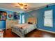 Bedroom with blue walls featuring wood floors, baseball-themed decor, and windows with blinds at 4617 Cloverlawn Dr, Tampa, FL 33624