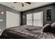 Bedroom featuring wood floors, a window with blinds, and dark colored walls at 4617 Cloverlawn Dr, Tampa, FL 33624