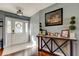 Bright foyer featuring white tile flooring, wood accents, decorative console table with Gathering photos at 4617 Cloverlawn Dr, Tampa, FL 33624