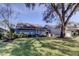 Charming single-story home with blue siding, lush lawn, and mature trees creating a serene curb appeal at 4617 Cloverlawn Dr, Tampa, FL 33624