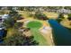 Aerial view of a golf course green with sand traps and a pond, surrounded by well-maintained landscaping at 4617 Cloverlawn Dr, Tampa, FL 33624