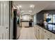White kitchen boasts stainless steel appliances, dark countertops and tile flooring at 4617 Cloverlawn Dr, Tampa, FL 33624