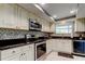 Charming kitchen features granite countertops, mosaic backsplash, stainless steel appliances, and white cabinetry at 4617 Cloverlawn Dr, Tampa, FL 33624