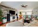 Open-concept living room with hardwood floors, wood accent wall, entertainment center, and pool table at 4617 Cloverlawn Dr, Tampa, FL 33624