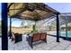 Seating area on stone patio with gazebo overlooking fenced pool and landscaped backyard at 4617 Cloverlawn Dr, Tampa, FL 33624