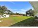 A spacious backyard is surrounded by a white fence and features lush green grass at 470 Sunset N Rd, Rotonda West, FL 33947