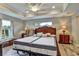 This bedroom features tray ceilings, wood-look tile flooring, and a large window with natural light at 470 Sunset N Rd, Rotonda West, FL 33947