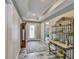 Inviting entryway with tile flooring, tray ceilings, and decorative shelving; complete with a wooden clock at 470 Sunset N Rd, Rotonda West, FL 33947