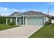 Charming single-story home with a two car garage, lush green lawn and well-maintained landscaping at 470 Sunset N Rd, Rotonda West, FL 33947