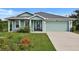 Charming one-story home featuring light green paint, a two-car garage, and a well-manicured front yard at 470 Sunset N Rd, Rotonda West, FL 33947